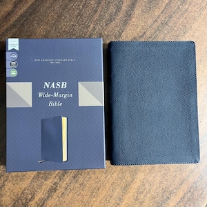 May include: A blue leather-bound Bible with the text "NASB Wide-Margin Bible" on the cover. The Bible is in a blue box with the same text on the cover.