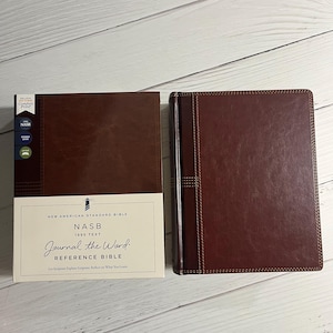 May include: A brown leather-bound journal with the title "NASB Journal the Word Reference Bible" and the text "1995 Text" printed on the front cover.