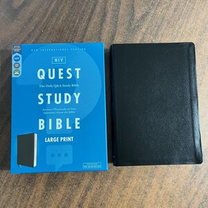May include: A blue and white box with the text "NIV QUEST STUDY BIBLE LARGE PRINT" and a black Bible with a black cover.