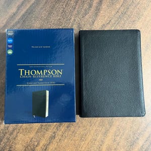 May include: A New International Version Thompson Chain-Reference Bible with a black leather cover and a blue box. The box reads "Revised and Updated" and "Known and Trusted Since 1908".