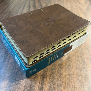 May include: A brown leather-bound Bible with gold accents and the text "Courage for Life Bible Study for Men" on the spine.