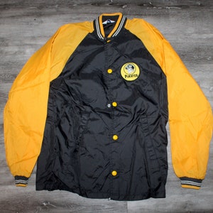 May include: A black and yellow baseball jacket with a Pittsburgh Pirates logo on the front. The jacket has a snap closure and a ribbed collar, cuffs, and waistband.