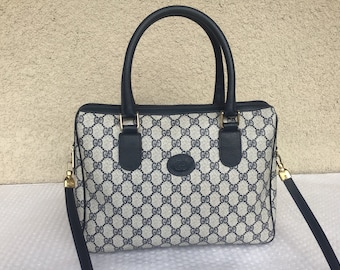 May include: A blue and white Gucci handbag with a black leather handle and a gold chain strap.