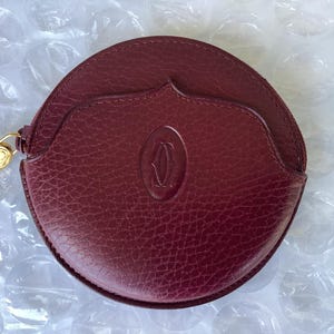 Monedero redondo de cuero Cartier vintage, usado, en excelente estado.