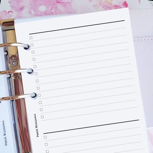 May include: A white planner page with a black line dividing the page in half. The top section has a list of 14 empty checkboxes. The bottom section has a list of 4 empty checkboxes. The text "Peach Blossoms" is written in black ink on the right side of the page.