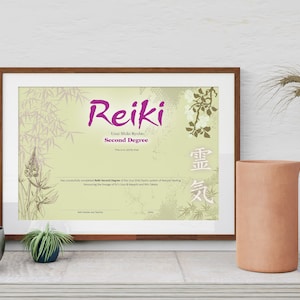 May include: A framed certificate with a light green background and a purple title that reads "Reiki Usui Shiki Ryoho Second Degree". The certificate has a floral design with bamboo and a Japanese character in the bottom right corner.
