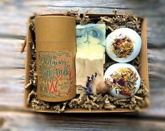 Könnte beinhalten: Eine Geschenkbox gefüllt mit Badeprodukten. Die Box enthält zwei Badebomben mit getrockneten Blumen, eine Seife und eine Tube Bademilch. Die Bademilchtube hat ein Etikett mit der Aufschrift "Natural & Handmade Soap Relaxing Bath Milk Mad About Nature madaboutnature.uk".