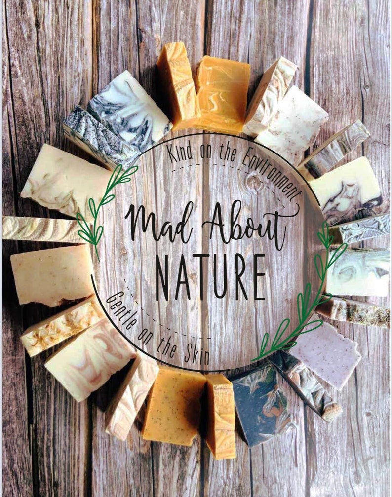 May include: A variety of handmade soap bars arranged in a circle on a wooden background. The soaps are in various colors and patterns, including brown, white, gray, and green. The text "Kind on the Environment" and "Mad About Nature" is written in a circle around the soaps. The text "Gentle on the Skin" is written below the soaps.