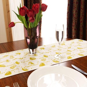 Table runner in linen with screen printed lemons design, washable with hemmed edge 215 x 32cm. Created and made by Curious Lions in the UK.