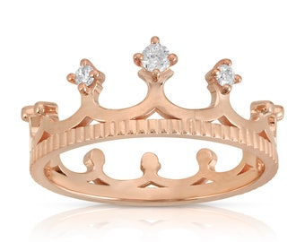 May include: A rose gold crown ring with three small clear cubic zirconia stones.