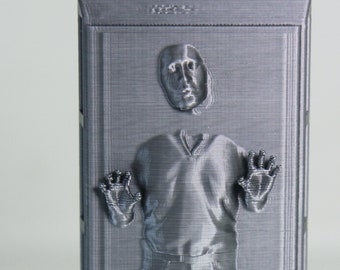 May include: A gray 3D printed model of a person frozen in carbonite. The model is detailed and shows the person's face, body, and hands.