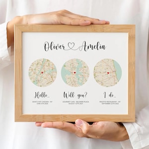 Puede incluir: Una lámina enmarcada con los nombres Oliver y Amelia y un corazón. Debajo hay tres mapas circulares con corazones rojos, etiquetados como Hello, Will you e I do, con ubicaciones y fechas específicas impresas debajo de cada uno.