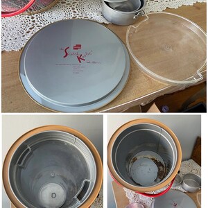 Peut inclure: Glaci&egrave;re vintage rouge et blanche &agrave; carreaux avec un couvercle argent&eacute; et un r&eacute;cipient int&eacute;rieur argent&eacute;. La glaci&egrave;re a une poign&eacute;e et une &eacute;tiquette qui indique "The Scotch Kooler".