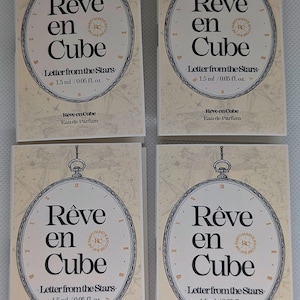 May include: Four perfume sample cards. Each card features the text "Rêve en Cube" in a stylized font, with "Letter from the Stars" below. The cards also state "1.5 ml / 0.05 fl. oz." and "Rêve en Cube Eau de Parfum".