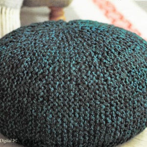 May include: A round, knitted ottoman in shades of teal and dark green. The textured surface is created by the tight knit stitches. The ottoman is a decorative and functional piece of home decor.