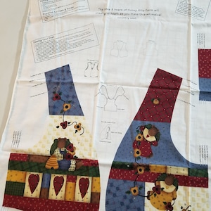 May include: A fabric panel for a child's vest, featuring a patchwork design with bear and sunflower motifs. The panel includes instructions and diagrams, with text that reads "Country Bears At Heart kid's Vest" and "Designed by Leslie Beck."