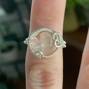 May include: A silver wire wrapped ring with two pink rose quartz stones.