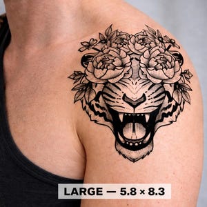 Può includere: Tatuaggio temporaneo in bianco e nero di una testa di tigre con una corona floreale. Il tatuaggio è etichettato "LARGE - 14,7 x 21,1 cm". La tigre ha la bocca aperta con denti visibili. La corona floreale è fatta di rose e foglie.