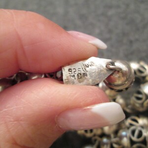 May include: A silver necklace with a silver tag that reads "925 Italy MCR".