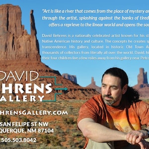 Op de afbeelding: Een rood, wit en blauw bord met de tekst "DAVID BEHRENS GALLERY" in wit. Het bord staat voor een rode rotsformatie. De tekst "DAVIDBEHRENSGALLERY.COM", "326 SAN FELIPE ST NW", "ALBUQUERQUE, NM 87104" en "505.503.8042" staat ook op het bord.