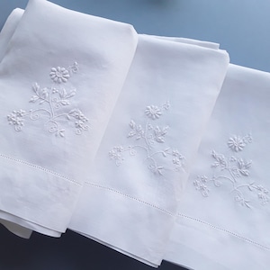 Unused pair of vintage embroidered Irish linen pillowcases plus a matching bolster cover.