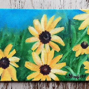 May include: A painting of yellow and black wildflowers against a blue sky background. The flowers are painted in a realistic style with visible brushstrokes.