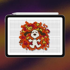 Puede incluir: Una tableta digital que muestra un patrón de punto de cruz de un perro de dibujos animados blanco con orejas negras acostado sobre un montón de hojas de otoño naranjas, rojas y amarillas. Un lápiz óptico blanco descansa en el borde superior.