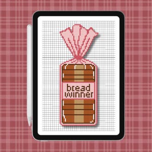 Könnte beinhalten: Ein digitales Tablet mit einem Kreuzstichmuster, das einen Laib Brot in einer Plastiktüte mit rosa Verschluss zeigt. Das Brot ist braun mit einem hellbeigen Kern, und der Text "bread winner" ist in dunkelbraunen Buchstaben mittig platziert.