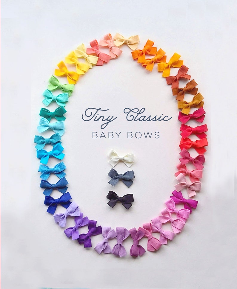 May include: A rainbow assortment of felt baby bows arranged in a circle. The bows are in various colors, including yellow, orange, red, pink, purple, blue, and green. The text "Tiny Classic BABY BOWS" is in the center of the circle.