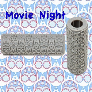 May include: Grey silicone rolling pin with a repeating pattern of glasses and party hats. The rolling pin is labelled "Movie Night".