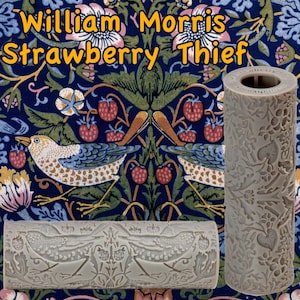 May include: A gray roller with a detailed relief pattern featuring birds, strawberries, and foliage, set against a backdrop of a William Morris "Strawberry Thief" fabric design. The text "William Morris Strawberry Thief" is displayed in yellow.