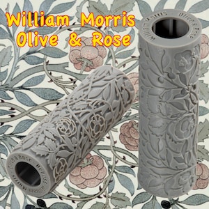 Peut inclure: Deux rouleaux de peinture gris avec un motif floral. Le motif représente des branches d'olivier et des roses. Le texte "William Morris Olive & Rose" est imprimé sur les rouleaux.