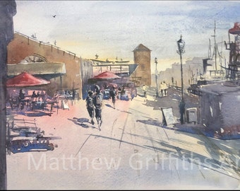 May include: A watercolor painting depicting a harbor scene with a red umbrella over outdoor seating, a tall lighthouse structure, and figures walking along a paved path. The text Matthew Griffiths Art is visible in white at the bottom of the image.