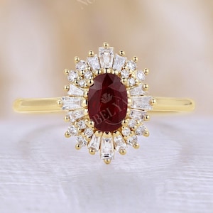 Könnte beinhalten: Ein goldener Ring mit einem ovalen Rubin als Mittelstein, umgeben von einem Halo aus Baguette- und Runddiamanten. Der Ring hat ein schlichtes Goldband. Das Design ist elegant und klassisch, geeignet für Verlobungen oder besondere Anlässe.