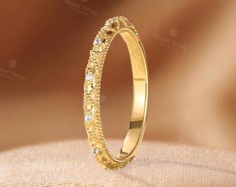 Puede incluir: Un anillo de oro amarillo con una superficie texturizada y bordes milgrain, adornado con pequeñas piedras blancas redondas espaciadas uniformemente a lo largo de la circunferencia exterior. El anillo tiene un interior pulido y un diseño detallado.