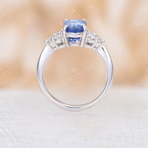 May include: A silver ring with a blue oval sapphire gemstone and smaller diamond accents.