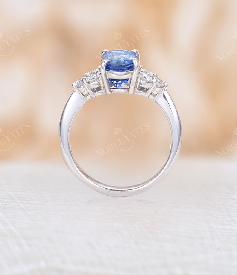May include: A silver ring with a blue oval sapphire gemstone and smaller diamond accents.