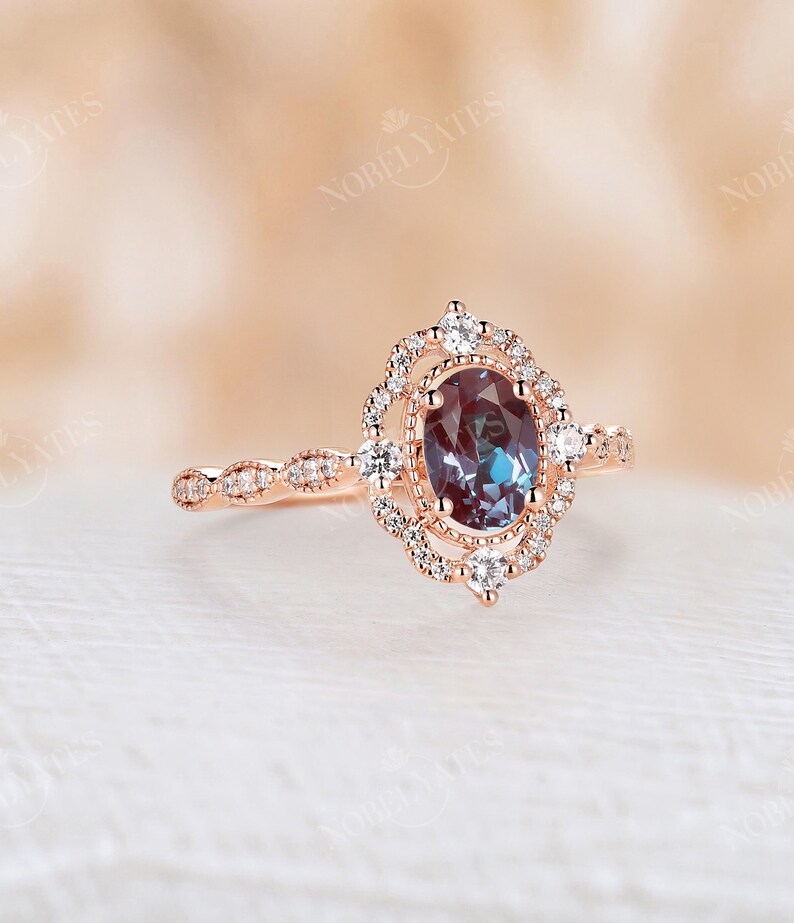 May include: A rose gold engagement ring with a large oval-shaped blue gemstone surrounded by a halo of smaller diamonds. The band is also set with smaller diamonds.