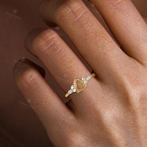 May include: A gold ring with a pear-shaped setting and small diamonds around the band.