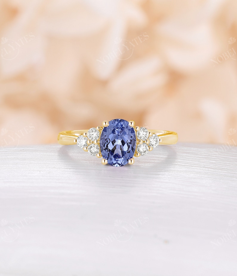 May include: A gold ring with a large oval-shaped blue gemstone surrounded by smaller white gemstones.