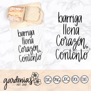 May include: A white kitchen towel with the Spanish phrase "barriga llena corazón contento" in black script. The towel is next to a wooden cutting board with bread slices. The Gardenias Art Shop logo is at the bottom.