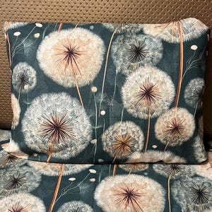 May include: A rectangular pillow and a matching flat fabric sheet featuring a dark forest green background with a repeating pattern of white and light brown dandelion seed heads on long, thin stems, creating a botanical print across the surface.