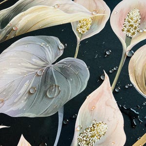 May include: A black tablecloth with a floral pattern of white, pink, and gold flowers. Water droplets are scattered across the surface of the tablecloth.