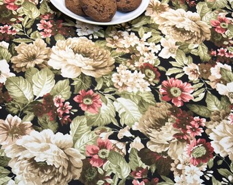 May include: Black tablecloth with a floral pattern featuring large white and brown flowers, smaller pink flowers, and green leaves.