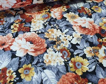 May include: Floral fabric featuring a dense pattern of large, open blooms in shades of orange, peach, yellow, and white, set against a dark navy background. The leaves are a muted gray-blue. The fabric is likely cotton or a similar material.