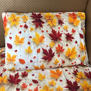 May include: A rectangular pillow and matching bedding set featuring a white background printed with a repeating pattern of vibrant autumn maple leaves in shades of yellow, orange, and deep red, interspersed with small red heart-shaped accents.
