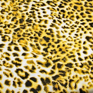 Op de afbeelding: Een close-up van een stof met een luipaardprint. De achtergrond is wit en de vlekken zijn zwart en geel.