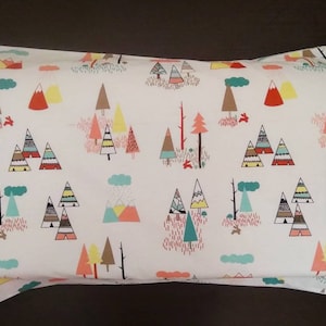 May include: White pillowcase with a colorful pattern of stylized trees and mountains. The pattern is repeated across the pillowcase.