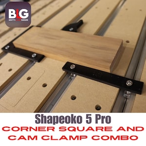 May include: A close-up shot of a Shapeoko 5 Pro corner square and cam clamp combo. The image shows a wooden block held in place by black clamps and silver hardware. The text "Shapeoko 5 Pro CORNER SQUARE AND CAM CLAMP COMBO" is displayed at the bottom.