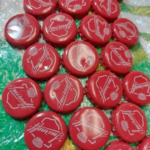 May include: A collection of red bottle caps with the word "Smirnoff" printed in white on each cap.